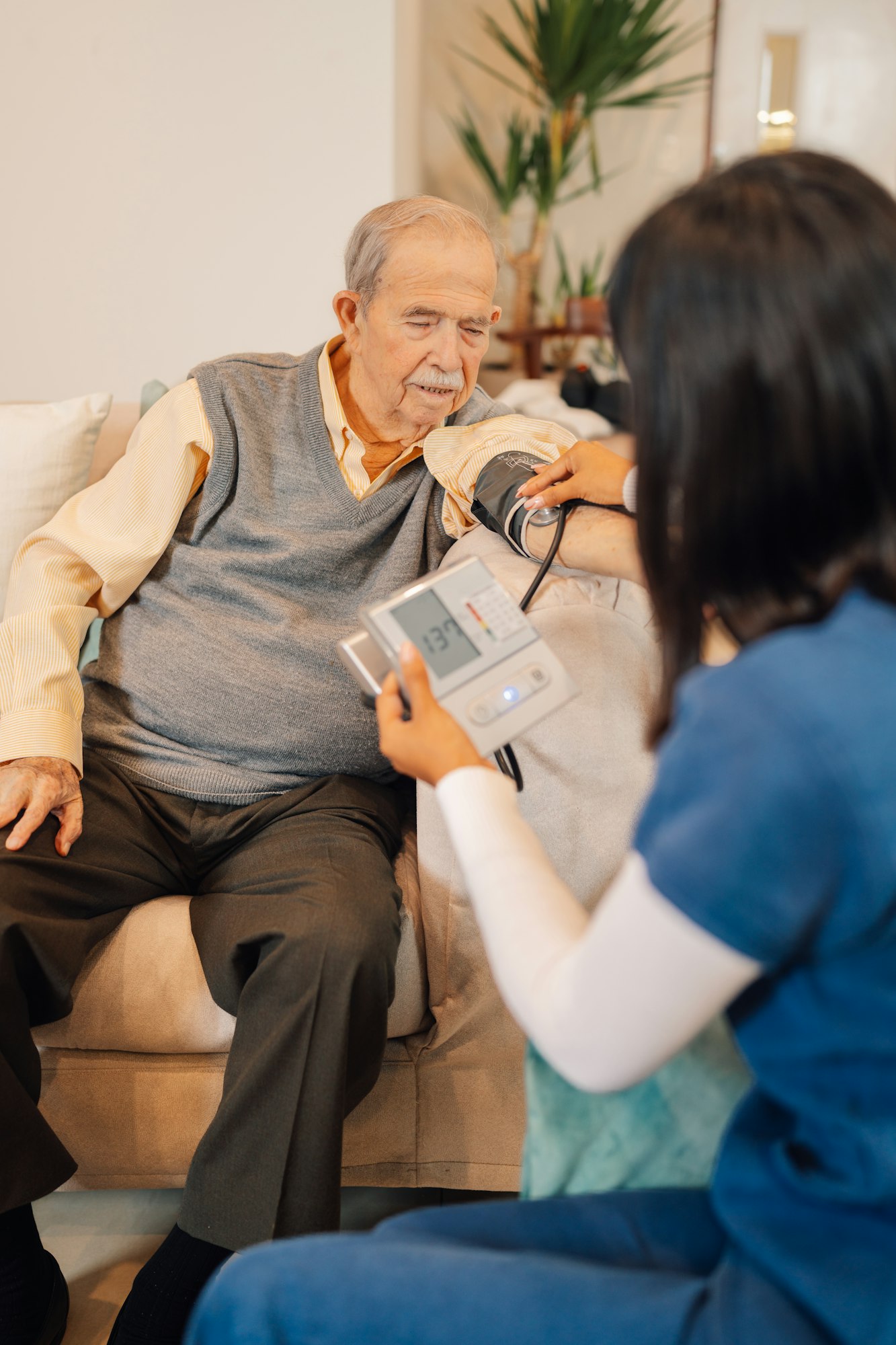 Caregiver measuring the blood pressure to an old man